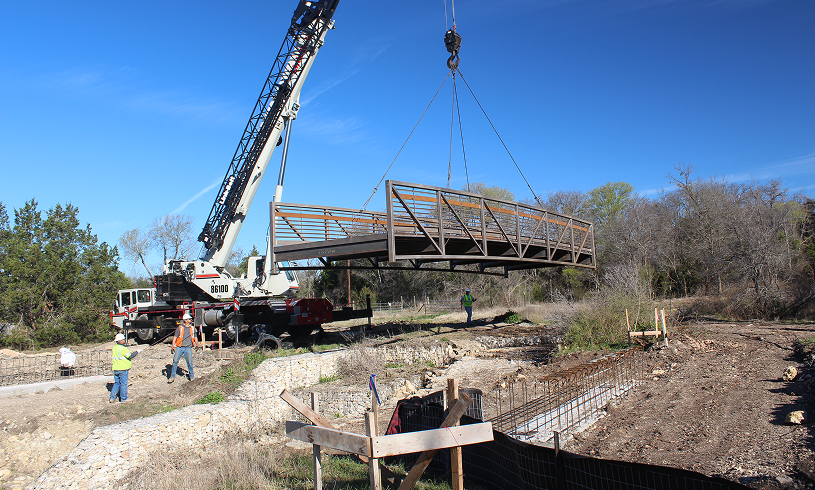 Crane lifting a metal bridge section