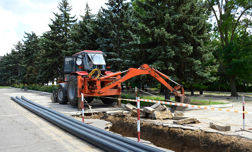 Roadwork with excavator and caution barriers