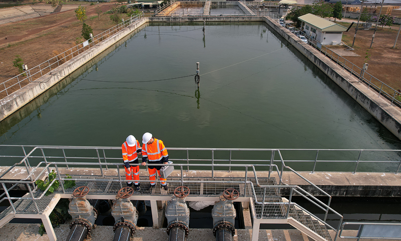Workers in safety gear at water facility.