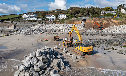 Construction vehicles working on a sandy beach