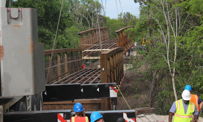 Workers installing a pedestrian bridge
