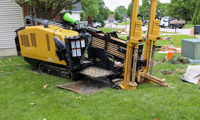 Yellow drilling rig near house