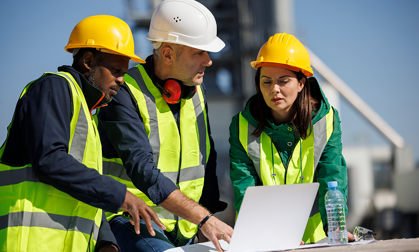 Workers in safety gear discussing project
