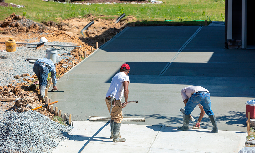 Men smoothing concrete for driveway project