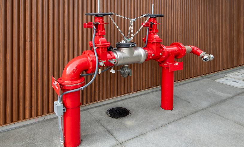 Industrial red piping against corrugated wall