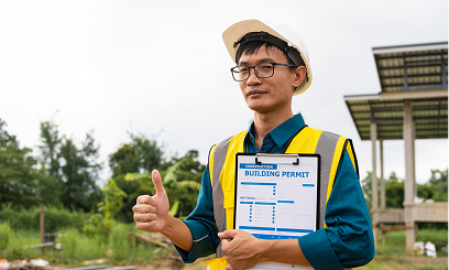 Engineer with thumbs up and permit