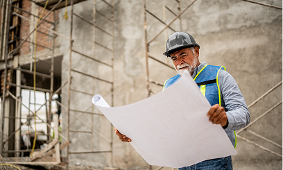 Engineer in hard hat studying plans