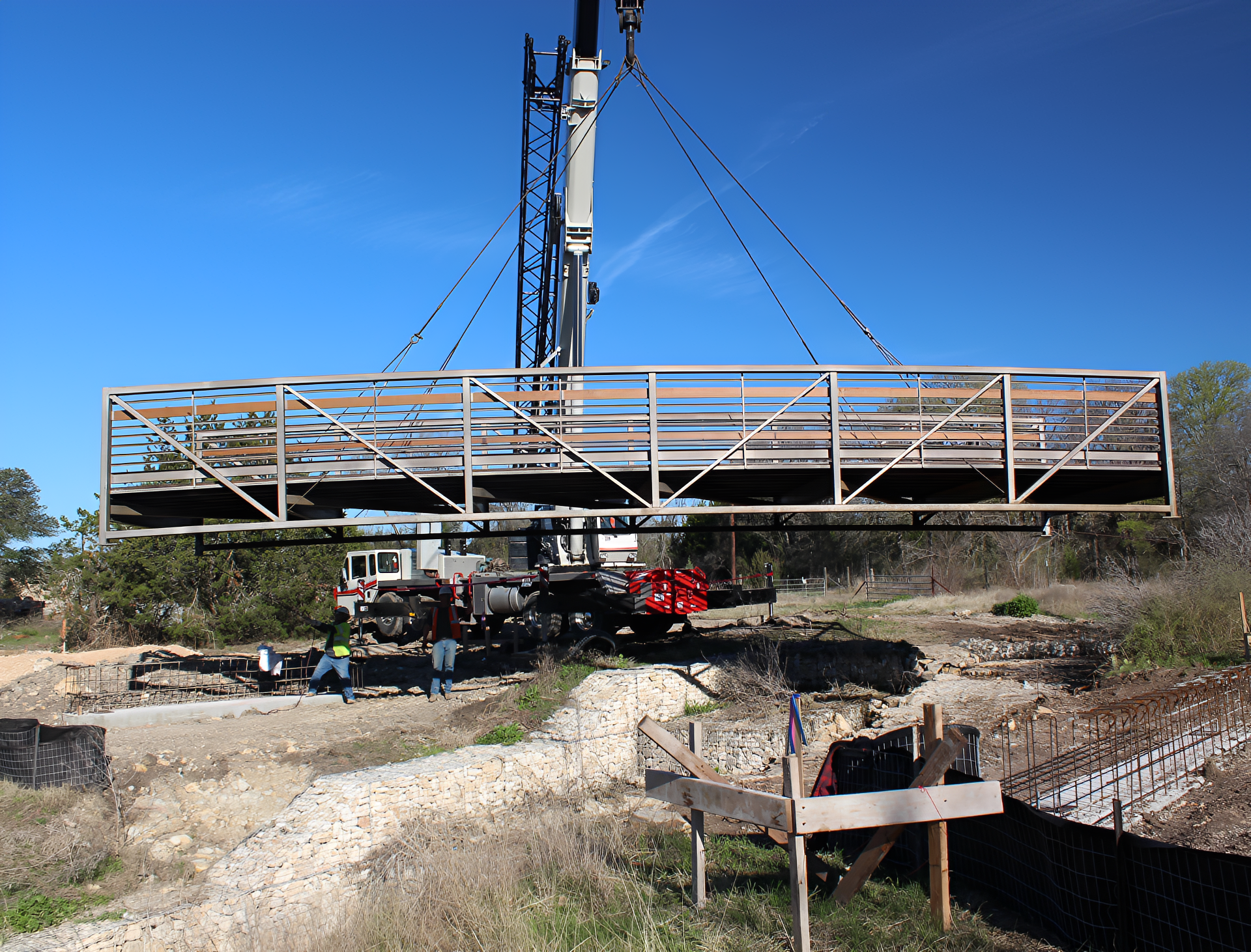 Crane lifting a metal bridge section