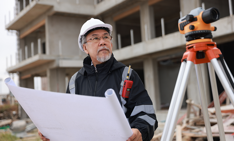 Construction worker examining blueprints on site