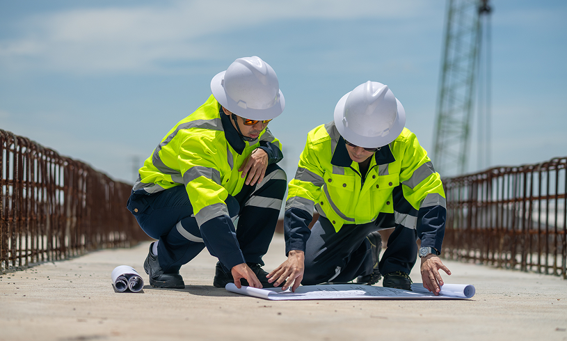 Engineers examining construction plans outdoors