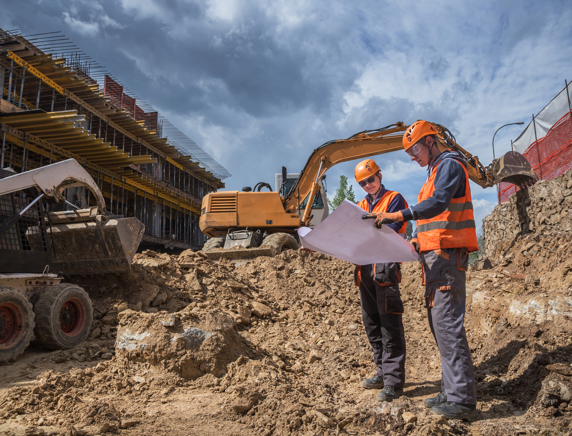 Excavator and workers at building site