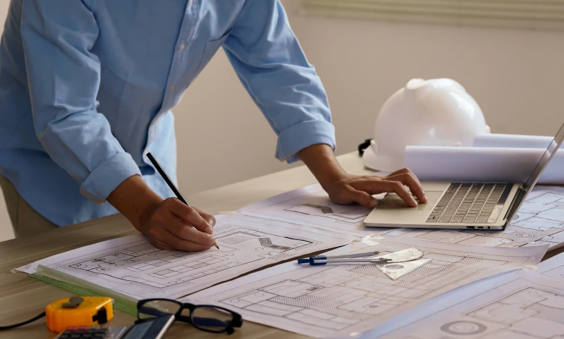 Engineer drafting plans at desk