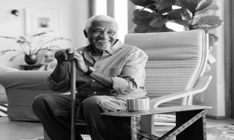 Senior man sitting with a walking cane.